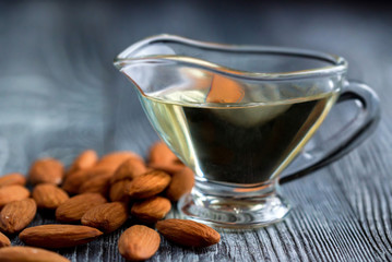 Sweet almond oil in glass jar and kernels