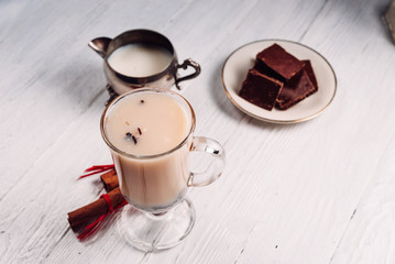 Hot green tea with milk and cinnamon on a white background