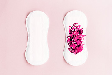 Two menstrual pads with red glitter on pastel pink colored background. Minimalist still life photography concept - obrazy, fototapety, plakaty