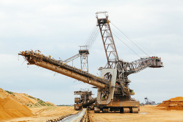 Fototapeta na wymiar coal mining. Giant wheel of bucket wheel excavator. Long conveyor belt transporting ore