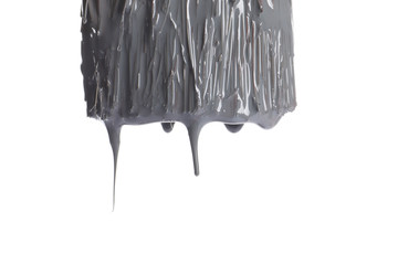 Brush dipped in grey paint on white background, closeup