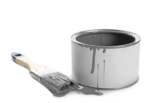 Can of grey paint and brush on white background