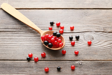 Black currants in spoon on grey wooden table