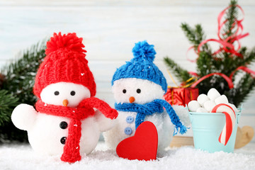 Small snowman toys with candy cane and marshmallows in bucket