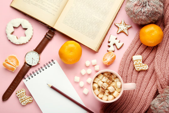 Cup of coffee with marshmallows, gingerbread cookies, book, mandarins and pink scarf