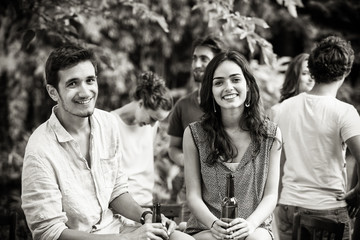 Group of young people celebrating outside. Focus on a  couple