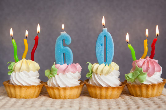 Happy 60 Birthday Cakes And Blue Numbers Candles On Grey Background