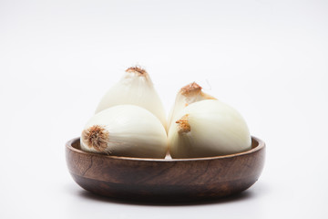 Onions on wood bowl isolated