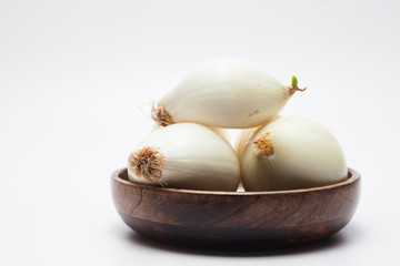 Onions on wood bowl isolated