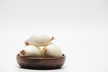 Onions on wood bowl isolated