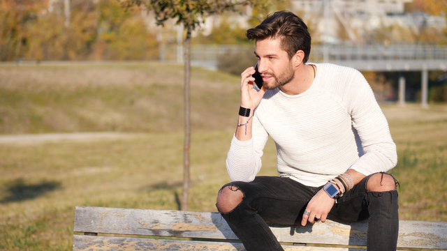 Handsome man making phone call outdoor in urban environment on with cell phone