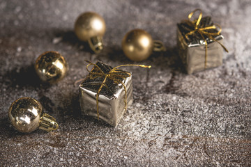 Christmas present with golden boxes and golden balls on snow. Dark background. Copy space.