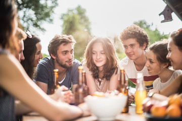 Group of young people sitting around a table outside