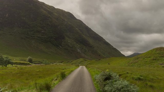 POV shot from a camera attached to the front of a vehicle driving through beautiful empty roads in the scottish highlands