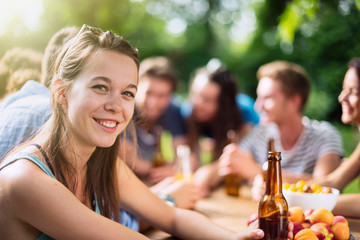 Group of young people having fun outside, focus on a young woman