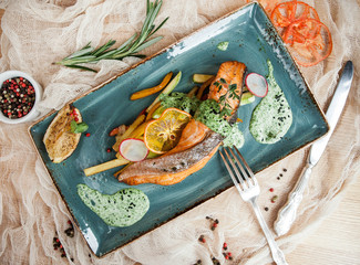 baked salmon steak with pepper and green sauce - 185421193