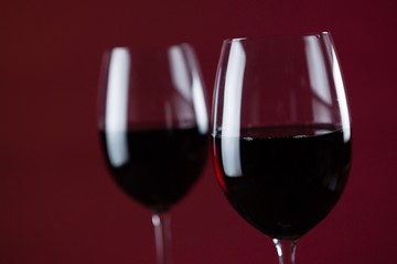 Two wine glasses against red background