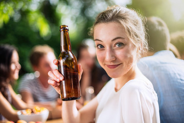 Group of young people having fun outside, focus on a young woman