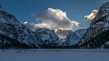 Evening in the winter mountain valley, alpie slope illuminated by reflected sunlight