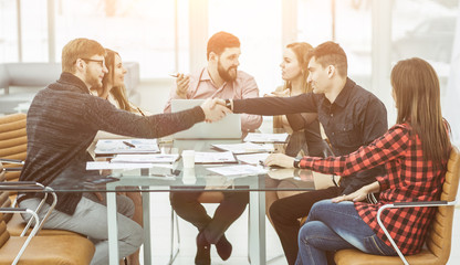 handshake financial partners and business team in the workplace