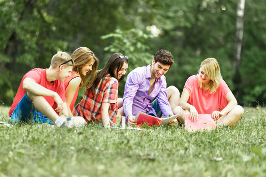 group of happy students with books of the Park on a Sunny day