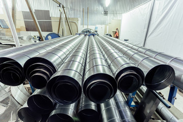 Cylindrical steel pipes. Round metal tubes in metalworking workshop