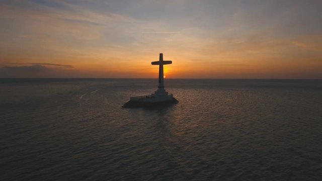 Aerial view Sunken Cemetery cross at sunset in Camiguin Island, Philippines. Large crucafix marking the underwater sunken cemetary of the coast of camiguin island near mindanao in the Philippines