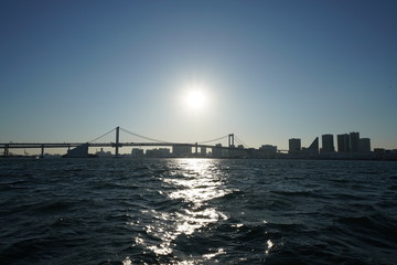 日本の東京都市景観・逆光「東京港の海上に映る太陽光」