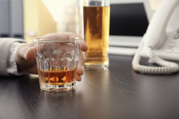 Man with glass of whiskey indoors. Alcohol dependence concept