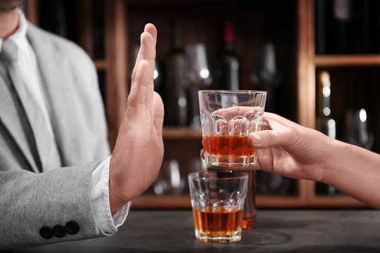 Man rejecting glass of alcohol in bar. Healthy lifestyle concept