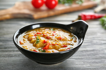 Bowl with tasty lentil soup on table