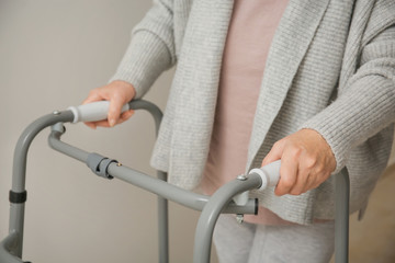 Elderly woman with walking frame indoors, closeup