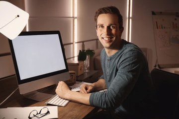 Young man working in office at night
