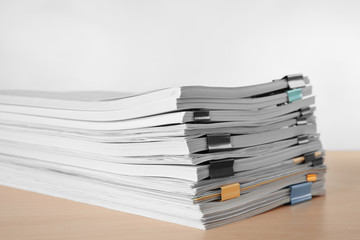 Stack of documents on table against light  background