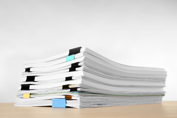 Stack of documents on table against light  background