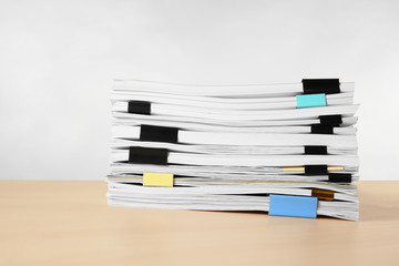 Stack of documents on table against light  background