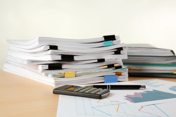 Stacks of documents on table against light background