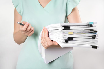 Woman with stack of documents against white background - obrazy, fototapety, plakaty