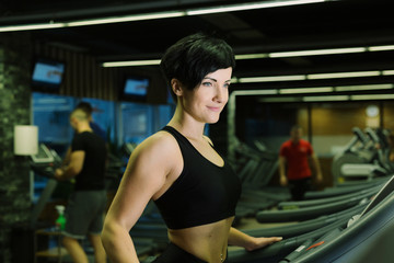 Fototapeta na wymiar Fit healthy sporty woman doing cardio exercise on treadmill. Female athlete workout on stepper at modern gym