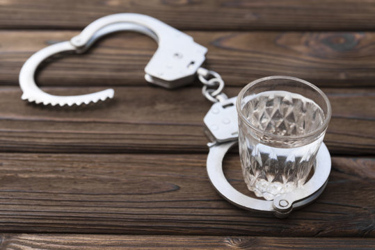 handcuffs, a glass of vodka. alcohol offense