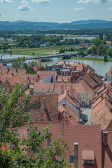 Fototapeta na wymiar Ptuj / Słowenia - sierpień 17, 2017: Widok na starówkę, rzekę Drawa i jezioro z zamku w Ptuj w lecie 2017