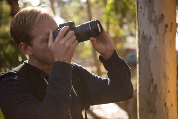 Fototapeta premium Man using dslr camera in the forest