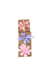 Three festive boxes with gifts tied with satin ribbon on a white background.