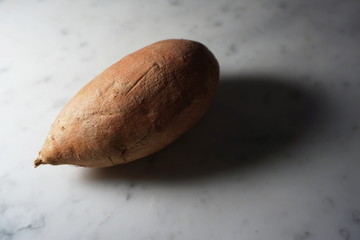 Isolated sweet potato on white marble