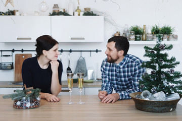 Young man and woman in the kitchen with christmas tree
