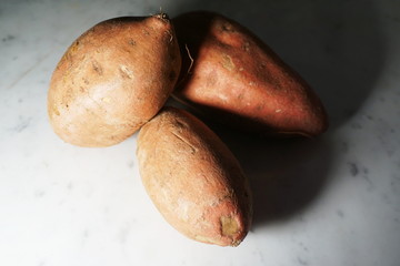 Isolated sweet potato on white marble