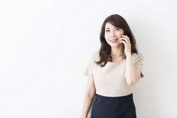 携帯電話で話すミドル女性