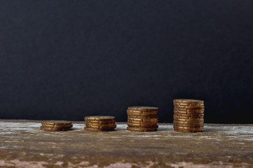 Money, business and Saving concept. Row of stack of coins with shadow on wooden table