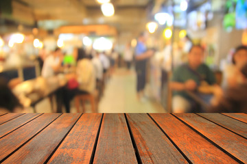 blurred wood table and people in food center with light bokeh.