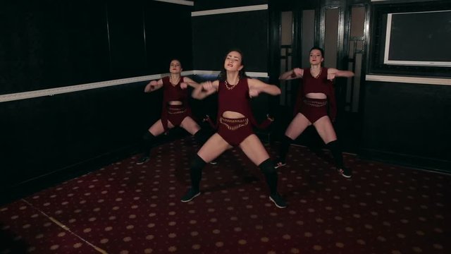 Three sexy girls dance twerk in a dark room, moving Asses.